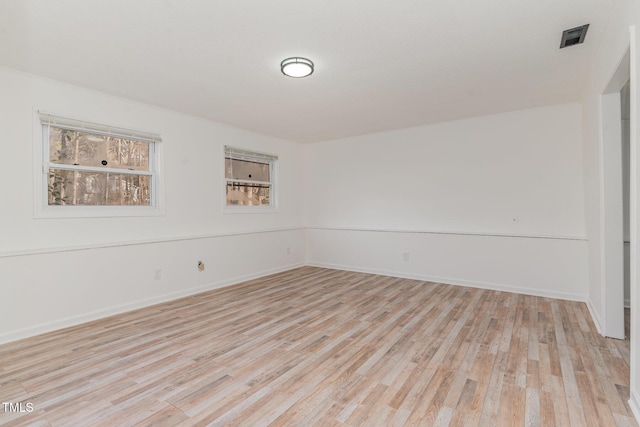 spare room with light wood-type flooring and baseboards