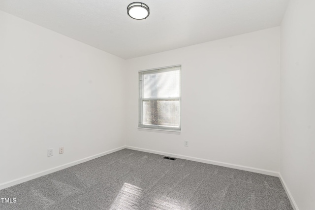 carpeted empty room featuring baseboards and visible vents