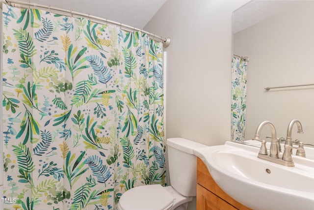 full bathroom with a textured ceiling, a shower with shower curtain, vanity, and toilet