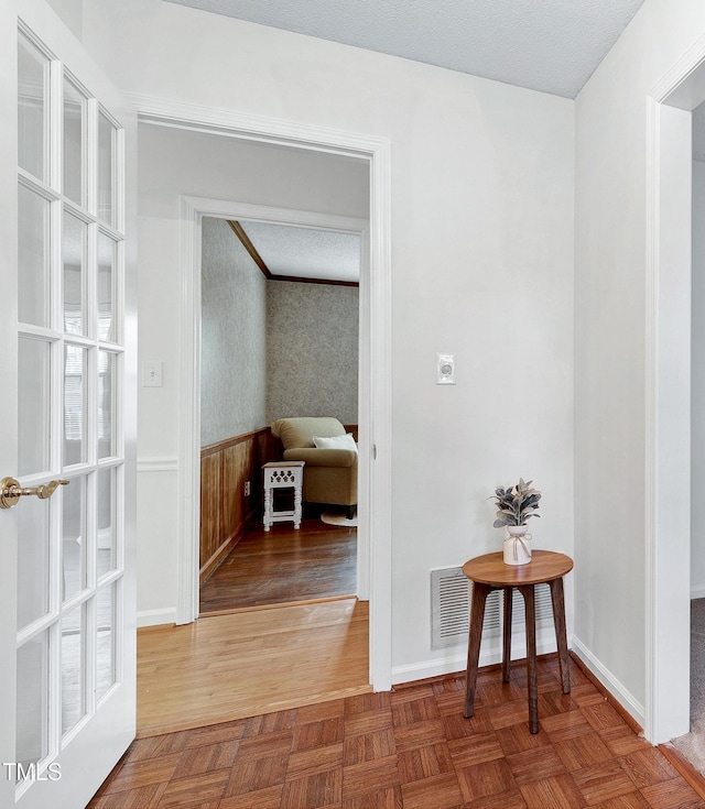 corridor featuring wood walls and parquet floors