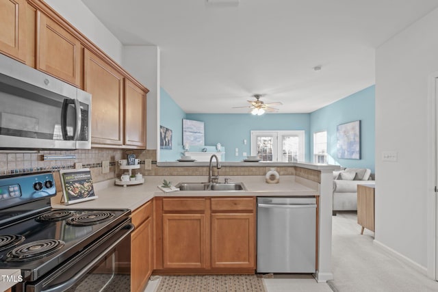 kitchen with sink, ceiling fan, decorative backsplash, appliances with stainless steel finishes, and kitchen peninsula