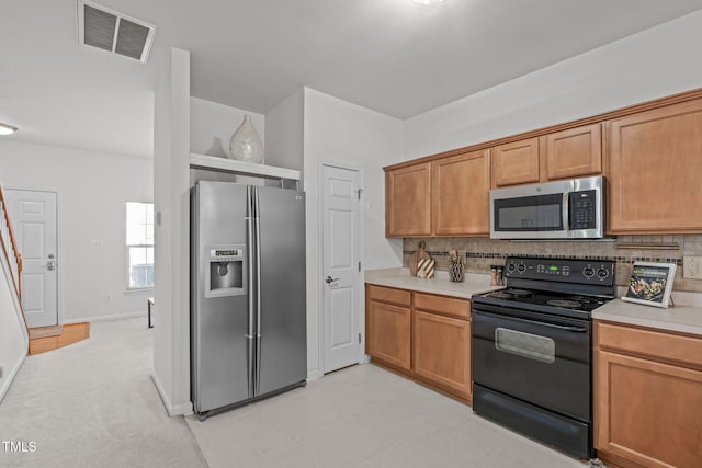 kitchen with tasteful backsplash, light colored carpet, and appliances with stainless steel finishes