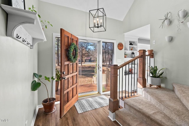 entrance foyer with a notable chandelier, hardwood / wood-style floors, and lofted ceiling