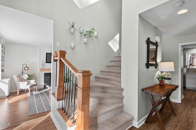 stairway with a fireplace, hardwood / wood-style floors, and a barn door