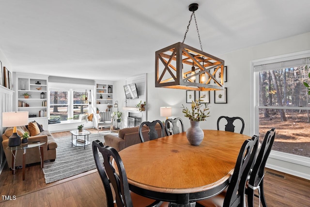 dining room featuring dark hardwood / wood-style flooring and built in shelves