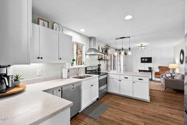 kitchen with kitchen peninsula, wall chimney exhaust hood, pendant lighting, stainless steel appliances, and white cabinets