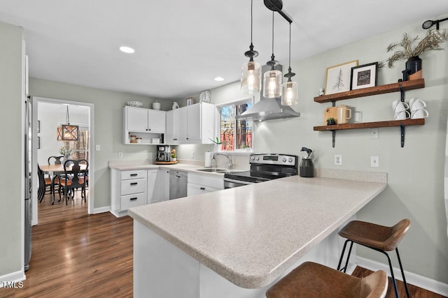 kitchen featuring stainless steel appliances, sink, white cabinets, kitchen peninsula, and hanging light fixtures