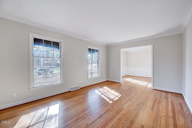 spare room featuring light hardwood / wood-style floors and crown molding