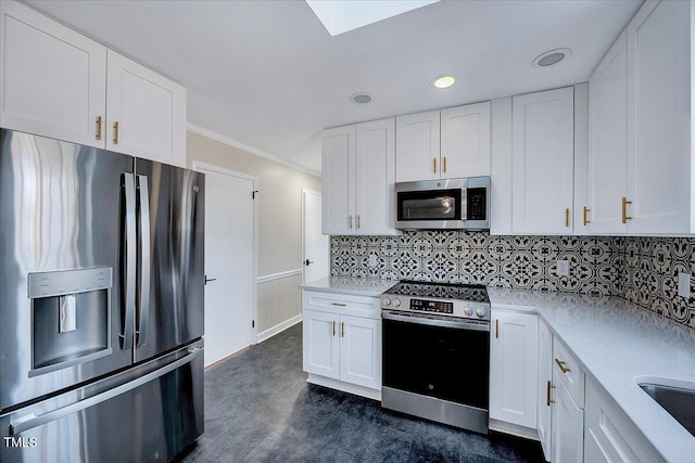 kitchen with crown molding, white cabinets, and stainless steel appliances