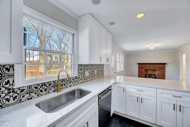 kitchen featuring kitchen peninsula, white cabinetry, sink, and stainless steel dishwasher