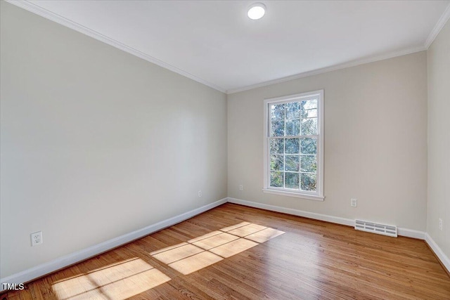 spare room with light wood-type flooring and crown molding