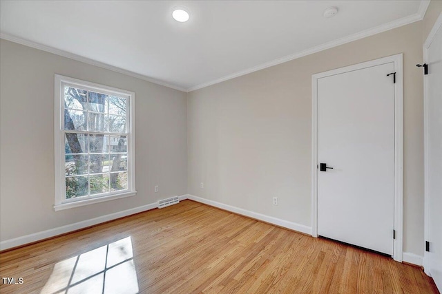 empty room featuring light hardwood / wood-style floors and ornamental molding