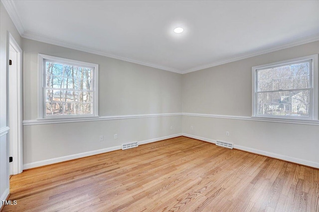 spare room featuring light wood-type flooring and crown molding