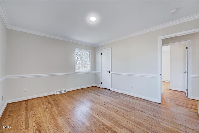 spare room featuring light hardwood / wood-style floors and crown molding