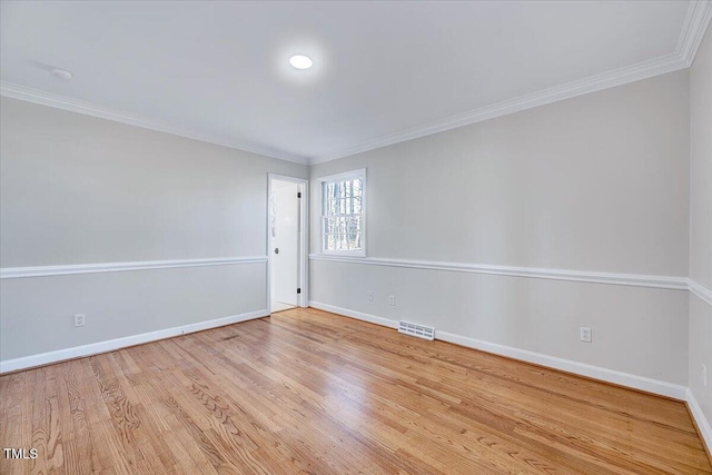 empty room featuring light hardwood / wood-style flooring and crown molding