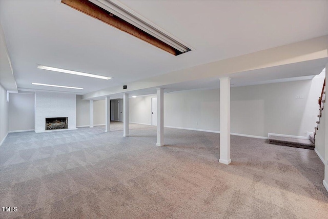 basement with a fireplace and light colored carpet