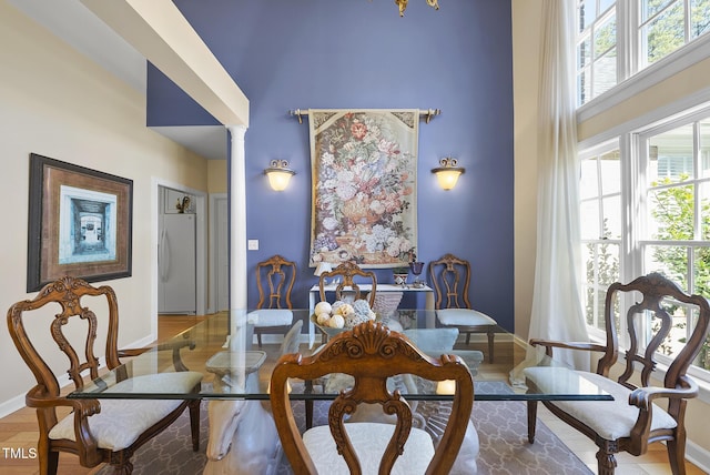 sitting room featuring decorative columns and a towering ceiling