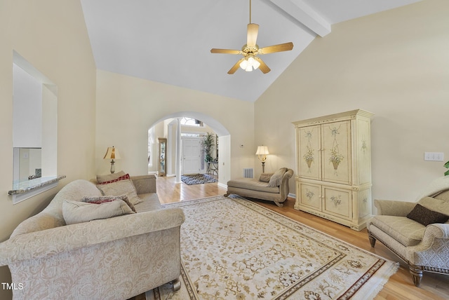 living room featuring light wood-type flooring, ceiling fan, beam ceiling, and high vaulted ceiling