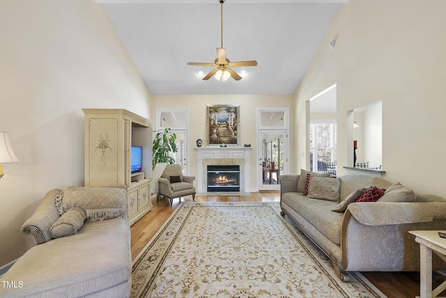 living room featuring high vaulted ceiling, ceiling fan, and light hardwood / wood-style flooring