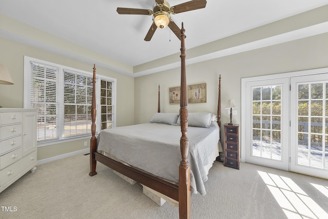 bedroom featuring ceiling fan, access to exterior, light carpet, and multiple windows