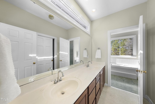 bathroom with a relaxing tiled tub and vanity