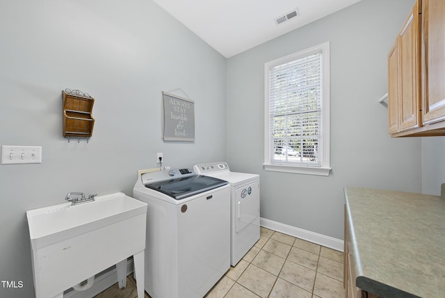 laundry area featuring cabinets, separate washer and dryer, sink, and light tile patterned flooring