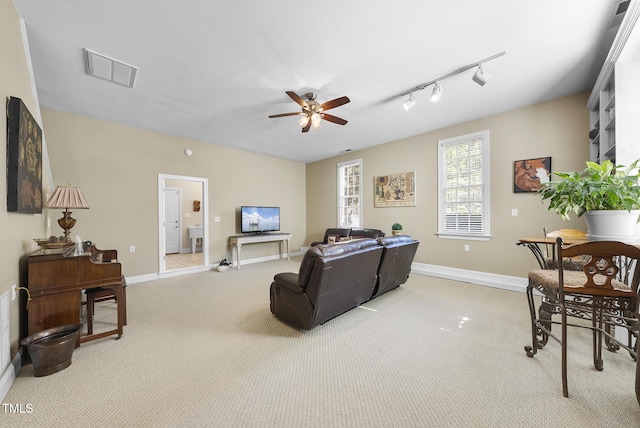 carpeted living room with ceiling fan and rail lighting