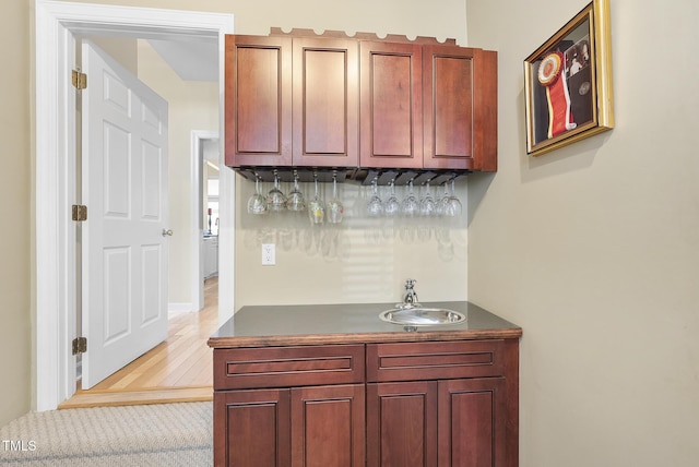 bar featuring sink and light hardwood / wood-style flooring