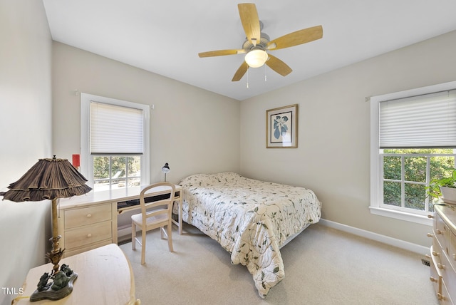 carpeted bedroom featuring ceiling fan and multiple windows