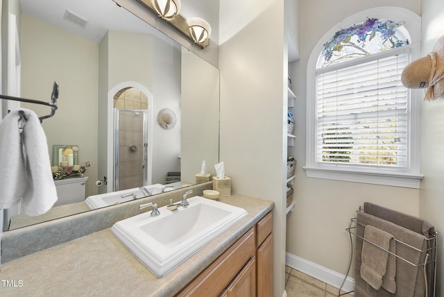 bathroom featuring vanity, tile patterned flooring, and a shower with door