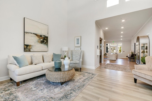 living room with french doors, light wood-type flooring, and crown molding