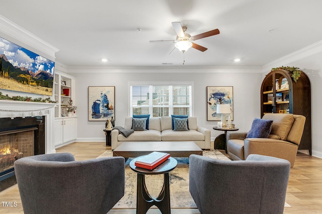 living room featuring built in shelves, crown molding, light hardwood / wood-style flooring, and ceiling fan