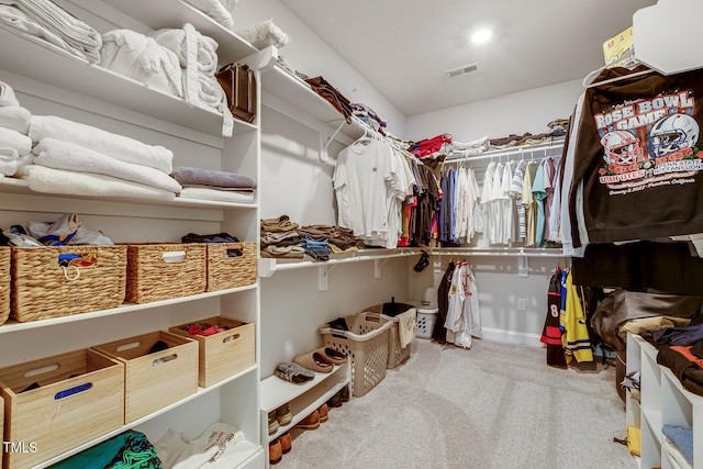 walk in closet featuring light colored carpet