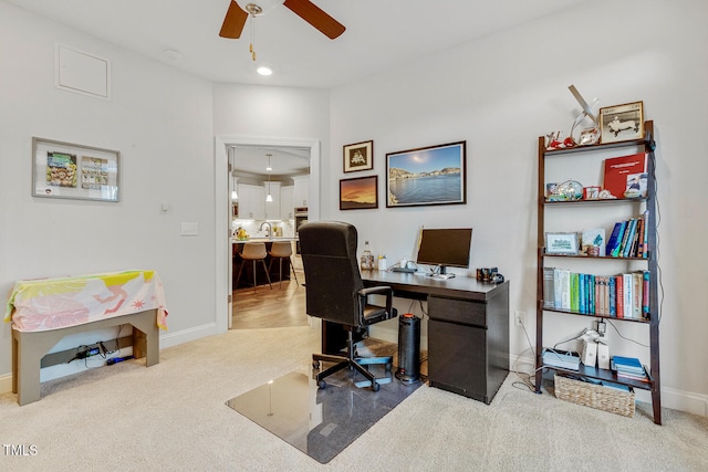 office area featuring ceiling fan, sink, and carpet