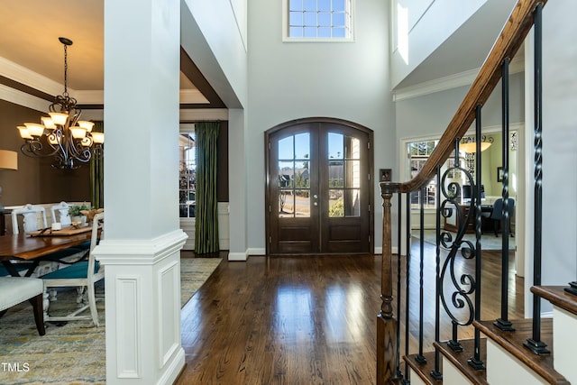 entrance foyer featuring a high ceiling, french doors, a wealth of natural light, and an inviting chandelier