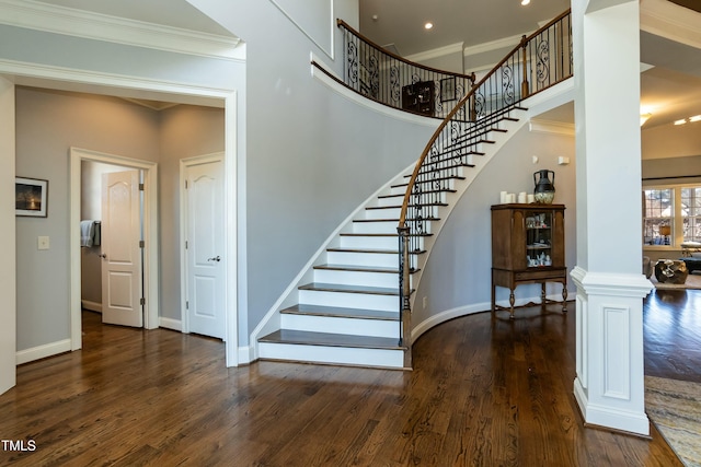 staircase featuring ornate columns, ornamental molding, and wood-type flooring