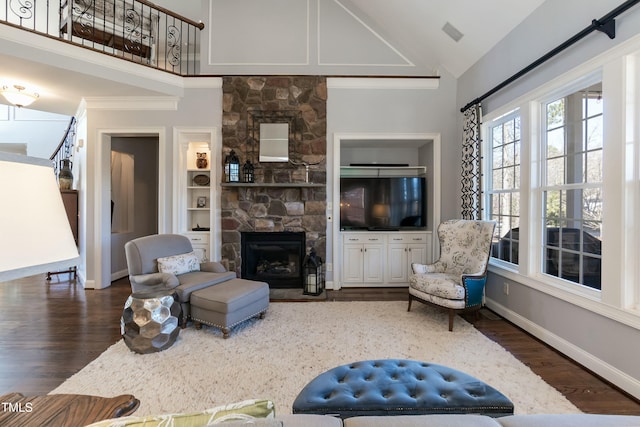 living room featuring dark wood-type flooring, lofted ceiling, and a stone fireplace