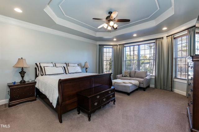 carpeted bedroom featuring a raised ceiling, ceiling fan, and ornamental molding