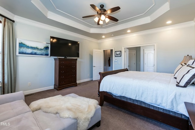 bedroom with ceiling fan, ornamental molding, dark colored carpet, and a tray ceiling