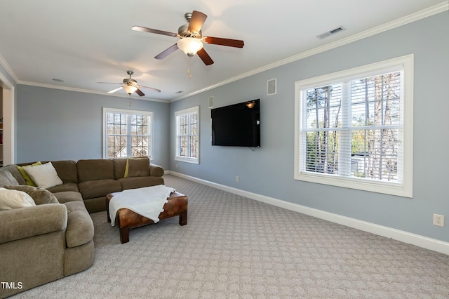 living room featuring ceiling fan, light colored carpet, crown molding, and a healthy amount of sunlight