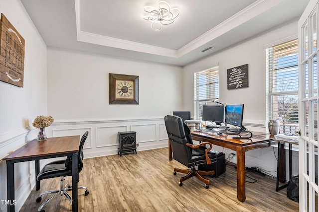 office area featuring light wood-type flooring, crown molding, and a tray ceiling