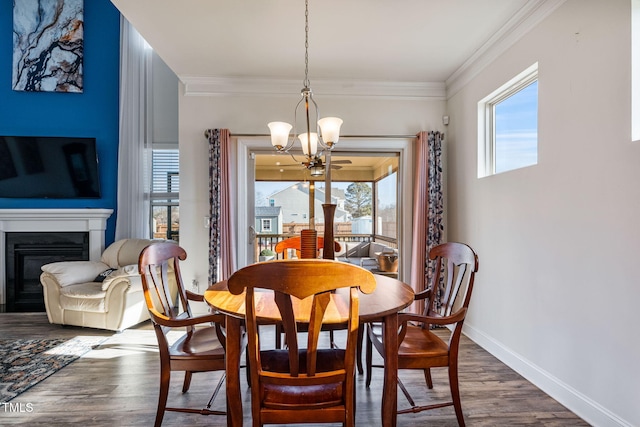 dining room with ornamental molding, dark hardwood / wood-style floors, and an inviting chandelier