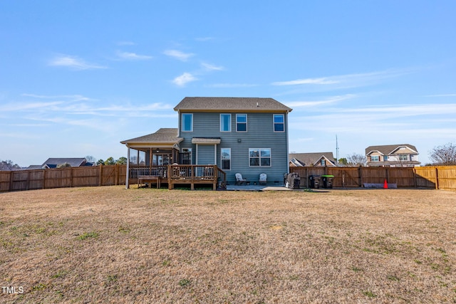 back of house featuring a wooden deck and a yard