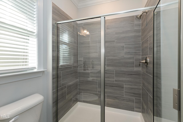 bathroom with toilet, an enclosed shower, and crown molding