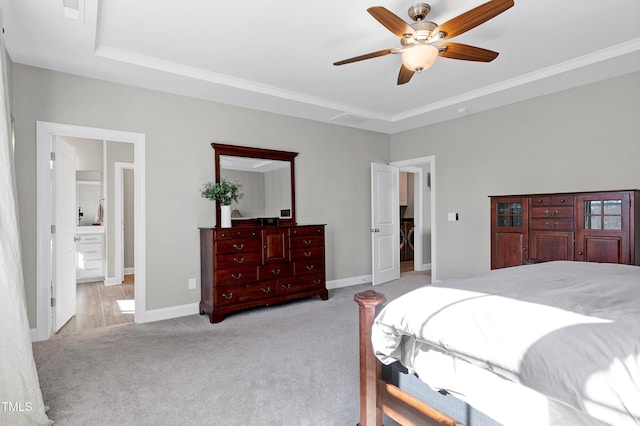 bedroom featuring ensuite bath, ceiling fan, a raised ceiling, crown molding, and light carpet