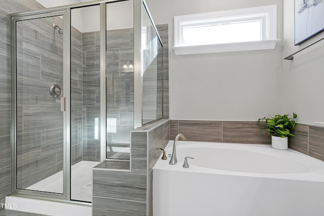 bathroom featuring shower with separate bathtub