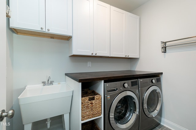 washroom featuring cabinets, sink, and washing machine and dryer