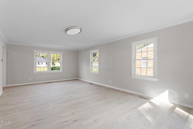 empty room with crown molding and light hardwood / wood-style floors