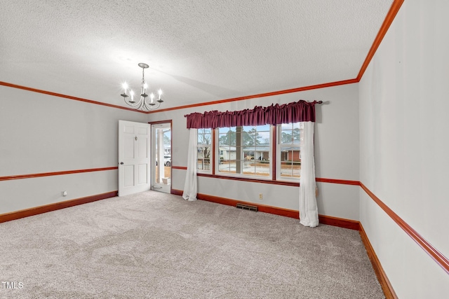 spare room with carpet flooring, a textured ceiling, crown molding, and an inviting chandelier