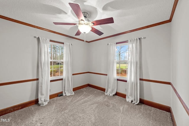 unfurnished room with carpet, ceiling fan, a healthy amount of sunlight, and ornamental molding